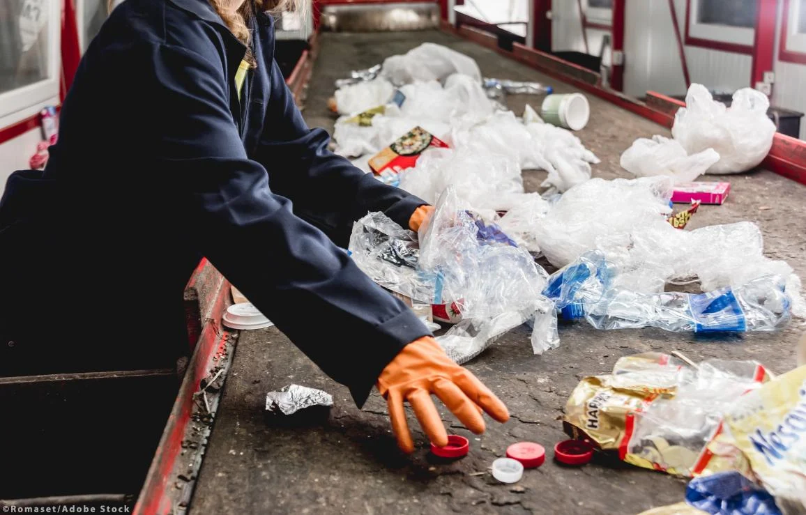 At modern recycling plant a workers sorting trash to be processed. ©Romaset/AdobeStock