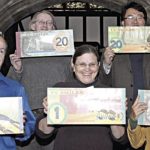 Изпълнителните директори на UC Smiles позират с новите банкноти.