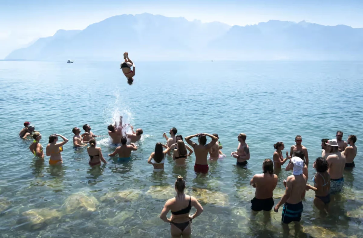 Посетителите на Фестивала на лозарите (Fête des Vignerons) се разхлаждат във водите на Женевското езеро.