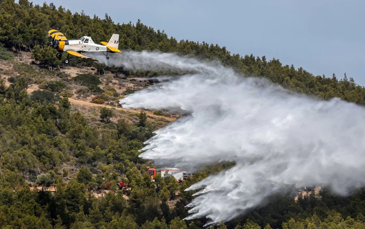 Пожарогасителен самолет PZL изпуска вода по време на мащабно учение за готовност, докато страната навлиза в пиковия сезон на пожарите, Лаврио, Гърция, 22 май 2025 г.